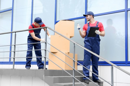 Movers carrying furniture through a West Hampstead property entrance